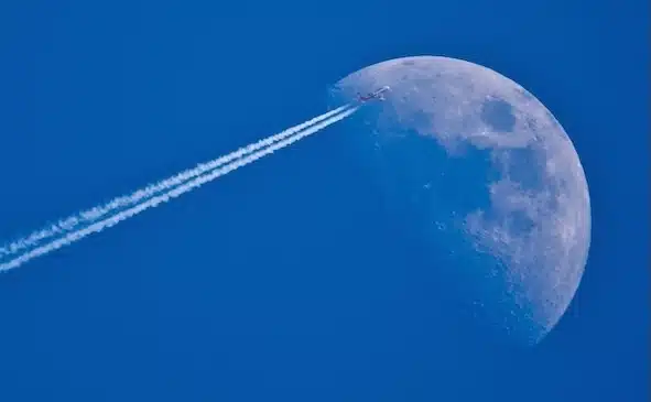 Blauer Himmel und grosser Mond, Flugzeug fliegt auf den Mond zu