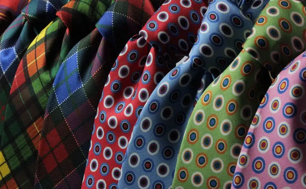 Verschieden farbige Kravatten, schön in einer Reihe drapiert. Auch eine schöne Kravatte kann die Selbstliebe vertiefen.
